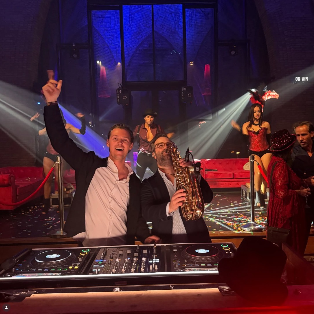 Daan Geeven met saxofonist en dansers tijdens een privéfeest